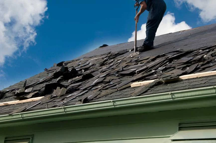 A Worker Removing Old Roof Shingles